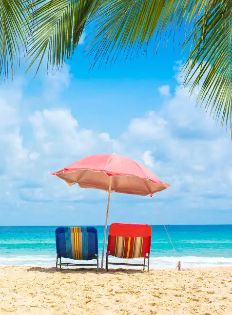 Détente sur les plages des Bahamas Parasol et chaises de plage détente farniente voyage sur mesure aux Bahamas