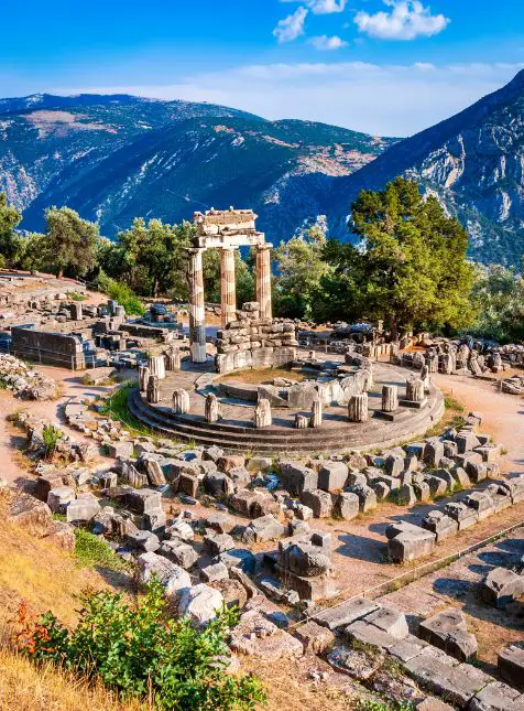 Site archéologique de Delphes avec temple circulaire et montagnes, Grèce antique, voyage sur mesure en Grèce