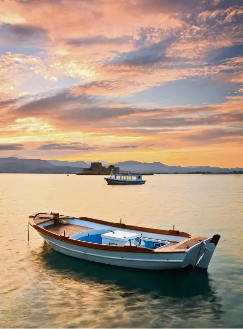 Bateaux de pêche traditionnels grecs au coucher de soleil sur mer Égée, voyage sur mesure en Grèce