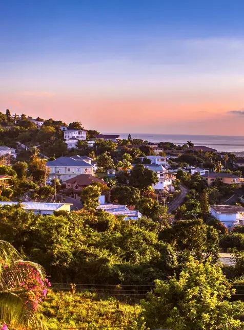 Village côtier jamaïcain au coucher du soleil avec maisons colorées - voyage sur mesure en Jamaïque