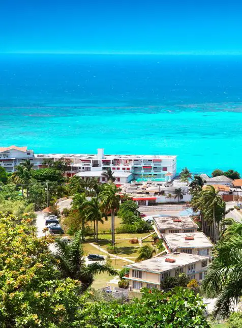 Resort jamaïcain moderne avec vue sur mer turquoise et palmiers - voyage sur mesure en Jamaïque