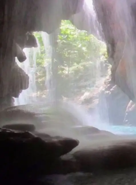 Grotte jamaïcaine avec cascade et lumière naturelle filtrée - voyage sur mesure en Jamaïque