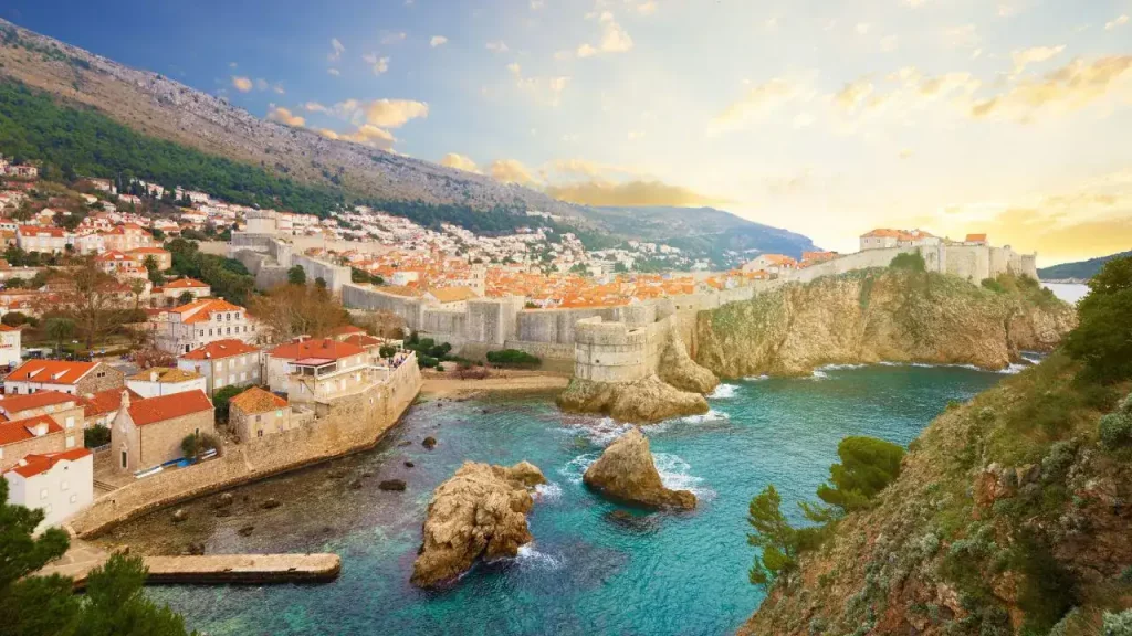 Vue panoramique de Dubrovnik au coucher du soleil avec remparts médiévaux et mer Adriatique turquoise pour voyage sur mesure en Croatie