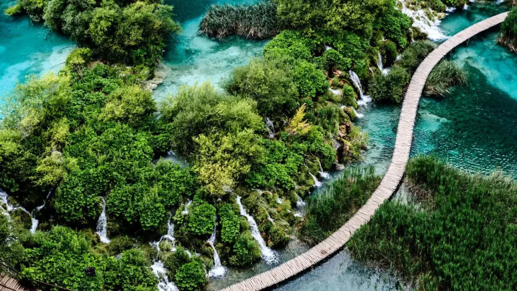 Passerelles en bois sur les lacs de Plitvice avec cascades et végétation luxuriante pour voyage sur mesure en Croatie