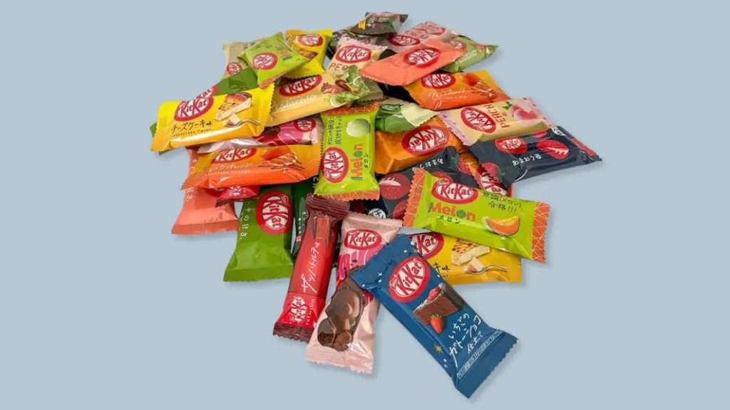 Tas de barres chocolatées Kit Kat japonaises aux emballages colorés représentant différentes saveurs locales comme le thé vert et les fruits