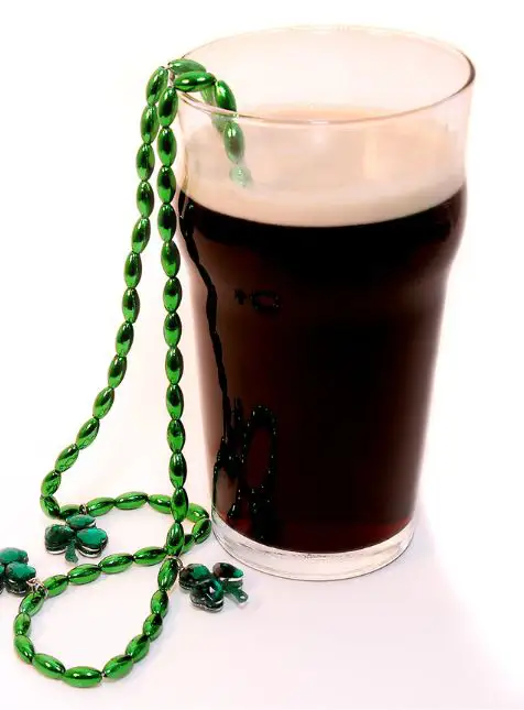 Traditions irlandaises : Stout et Trèfle Pinte de bière stout irlandaise traditionnelle avec trèfle vert porte-bonheur - voyage sur mesure Irlande gastronomique