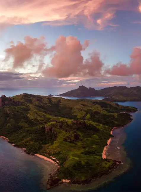 Vue aérienne îles fidjiennes collines vertes océan turquoise coucher de soleil pour voyage sur mesure Fidji aventure