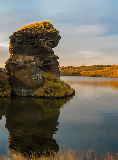 Formation rocheuse de lave recouverte de mousse se reflétant dans le lac Mývatn - voyage sur mesure en Islande Les Sens du Voyage Lyon