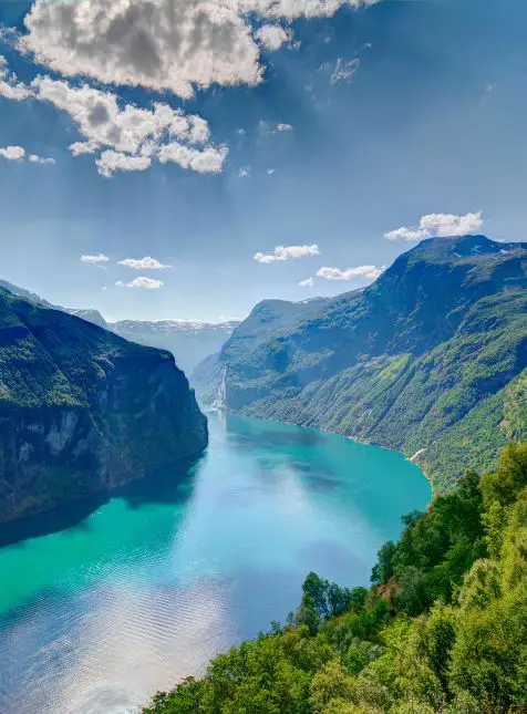 Vue panoramique du fjord norvégien aux eaux turquoise entre montagnes verdoyantes lors d'un voyage sur mesure en Norvège