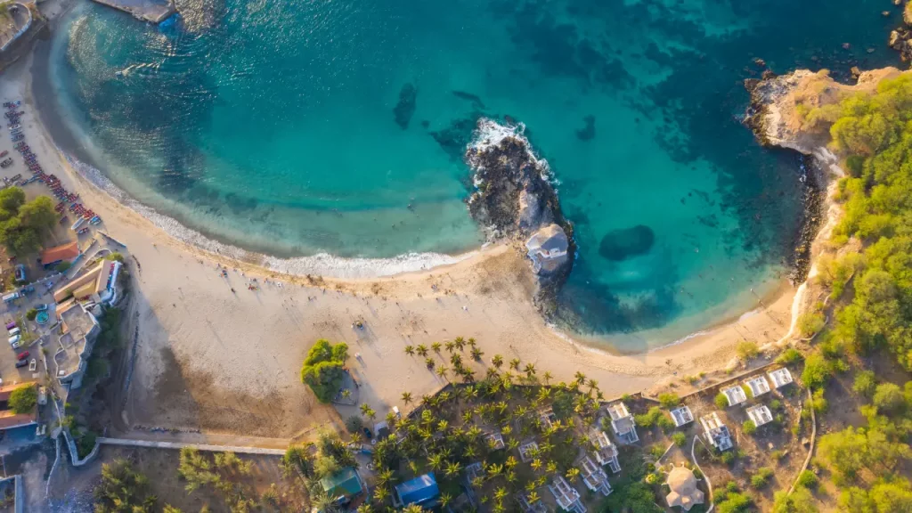 Vue aérienne d’une plage en arc de cercle et d’un lagon turquoise au Cap-Vert, idéale pour un séjour balnéaire en voyage sur mesure au Cap-Vert