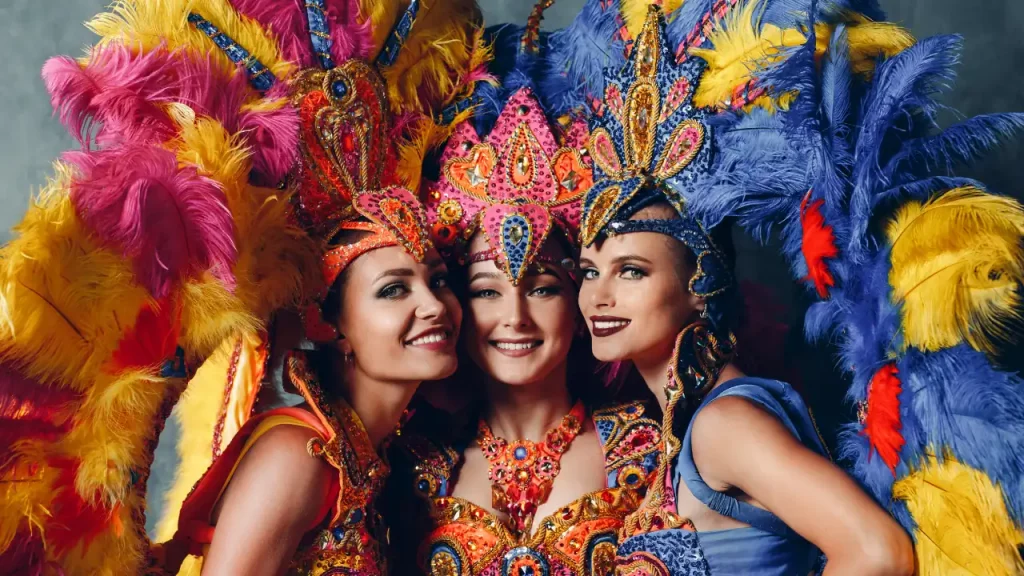 Trois danseuses en costumes de plumes colorées du carnaval de Rio, expérience festive lors d'un voyage sur mesure au Brésil