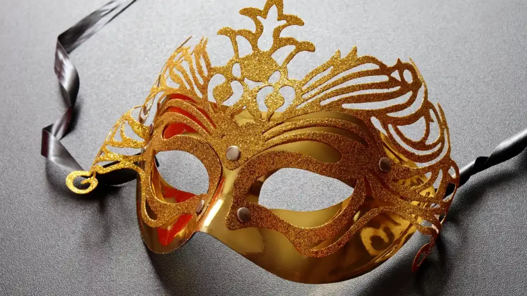 Masque de carnaval doré à paillettes sur fond gris, artisanat festif lors d'un voyage sur mesure au Brésil