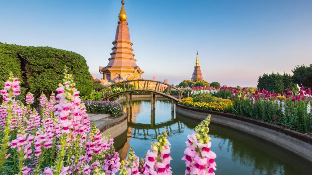 Pagodes royales et jardins fleuris se reflétant dans un bassin au sommet du Doi Inthanon lors d'un voyage sur mesure en Thaïlande