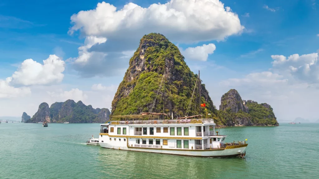 Jonque de croisière naviguant face à un piton calcaire dans la baie d'Halong lors d'un voyage sur mesure au Vietnam
