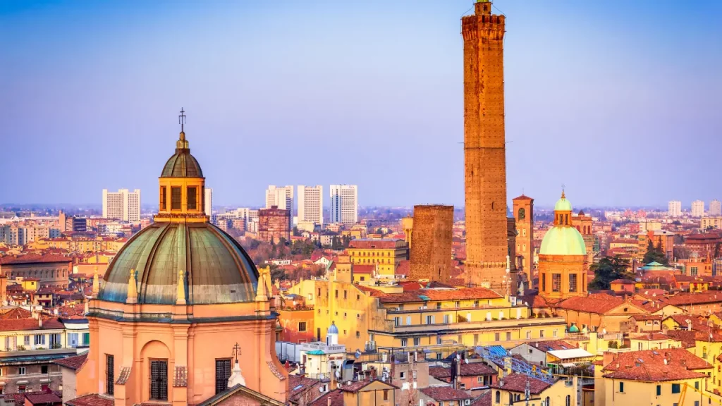 Tour des Asinelli et toits de Bologne au crépuscule avec dômes de basiliques lors d'un voyage sur mesure en Italie