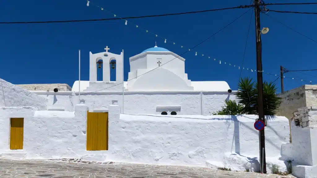 Église orthodoxe blanche à dôme bleu et clocher dans le village de Kimolos lors d'un voyage sur mesure en Grèce
