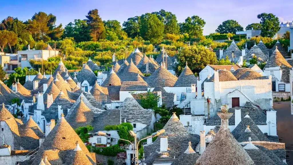 Toits coniques des trulli d'Alberobello en pierre et façades blanches dans la lumière du soir lors d'un voyage sur mesure en Italie