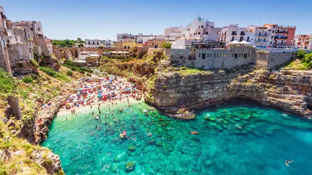 Plage de Polignano a Mare encadrée de falaises calcaires et eaux turquoise lors d'un voyage sur mesure en Italie