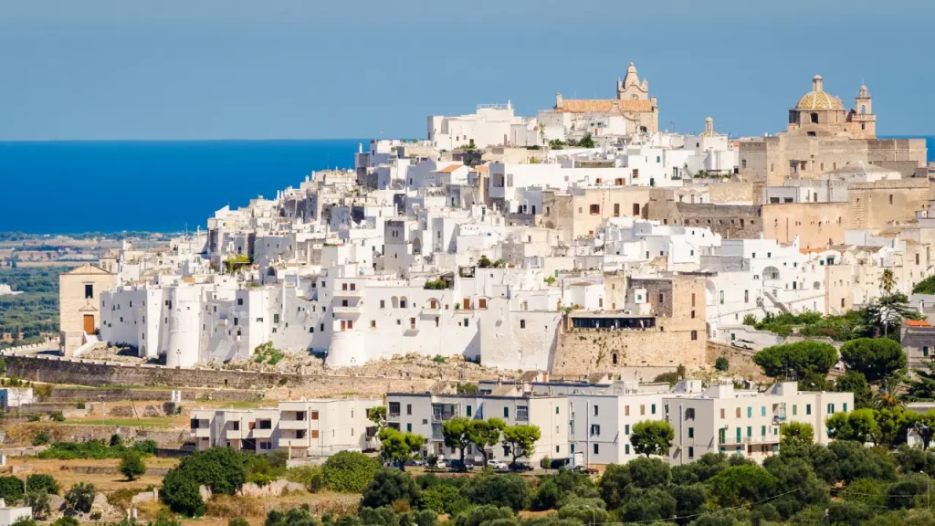 Ville blanche d'Ostuni sur sa colline avec la mer Adriatique en arrière-plan lors d'un voyage sur mesure en Italie