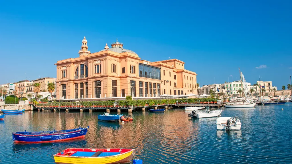 Théâtre Margherita et barques colorées dans le port de Bari sous un ciel bleu lors d'un voyage sur mesure en Italie