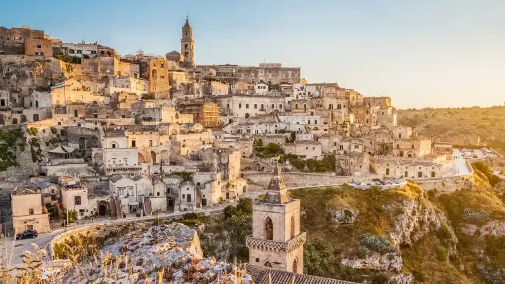 Les Sassi de Matera et leurs maisons troglodytiques baignés dans la lumière dorée du coucher de soleil lors d'un voyage sur mesure en Italie