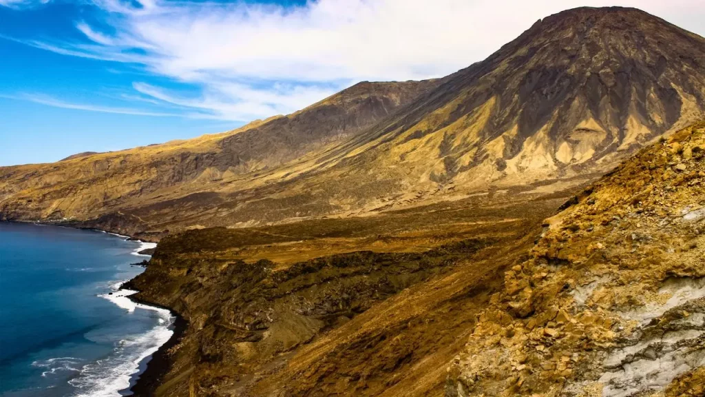 Côte volcanique aride avec falaises rocheuses et océan bleu
