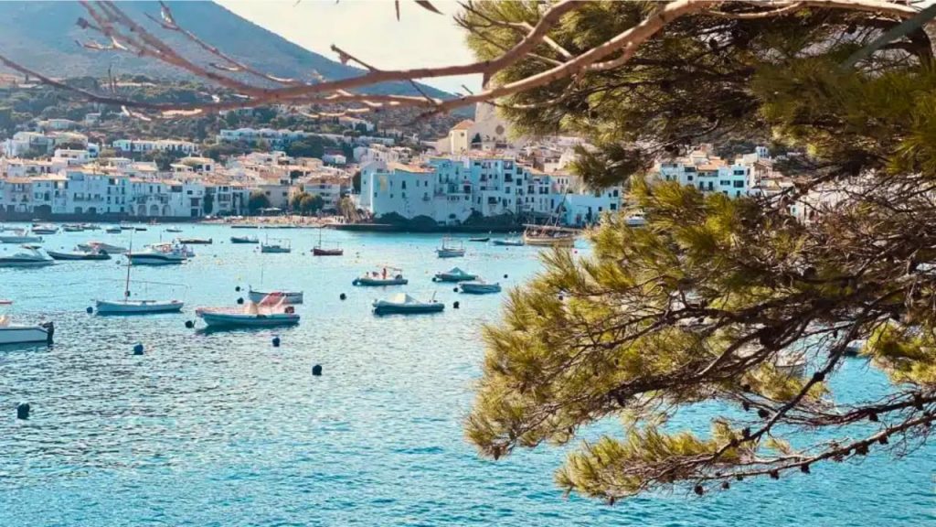 Village méditerranéen blanc avec bateaux dans une baie turquoise