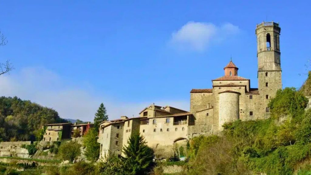 Village médiéval catalan avec clocher roman sous ciel bleu